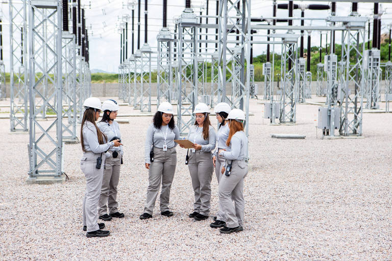 Imagem mostra mulheres conversando numa usina eólica.