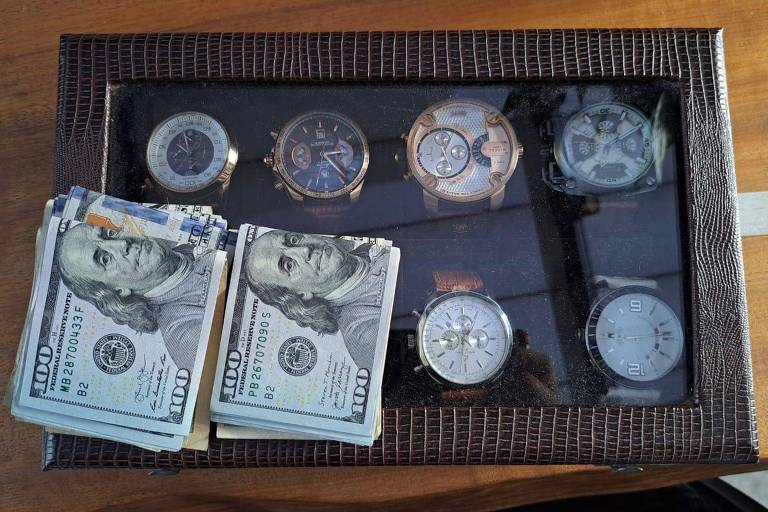 Relógios dentro de uma caixa e notas de dólares acima