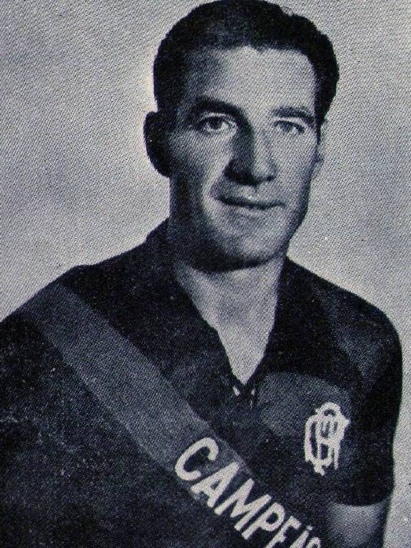 Fotografia em preto e branco de Carlos Volante, argentino que jogou pelo Flamengo nas décadas de 1930 e 1940; ele usa a camisa do time carioca e há nela uma faixa com a palavra "campeão"