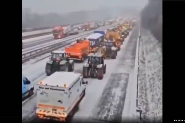 Captura de tela de vídeo mostra estrada de duas mãos com neve e caminhões