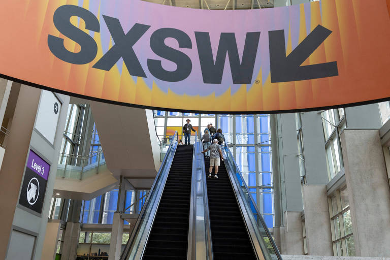 Participantes usam a escada rolante durante a Convenção de Austin na Conferência South by Southwest em Austin, Texas, EUA