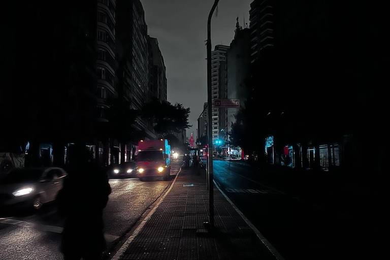 Avenida São João, no centro de São Paulo, totalmente escura, aparecendo apenas os faróis dos carros