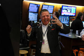 Traders react after the closing bell on the floor of the NYSE in New York