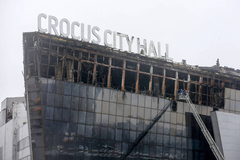 Imagem mostra prédio queimado com o letreiro Crocus City Hall no teto. O lugar foi atacado por terroristas na sexta
