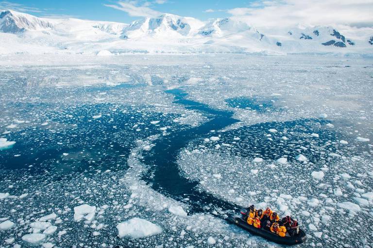 Grupo de cientistas em barco na Antártida