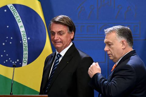 Hungary's Prime Minister Viktor Orban (R) and Brazil's President Jair Bolsonaro arrive to give a joint press conference on February 17, 2022 in Budapest, Hungary. (Photo by Attila KISBENEDEK / AFP)