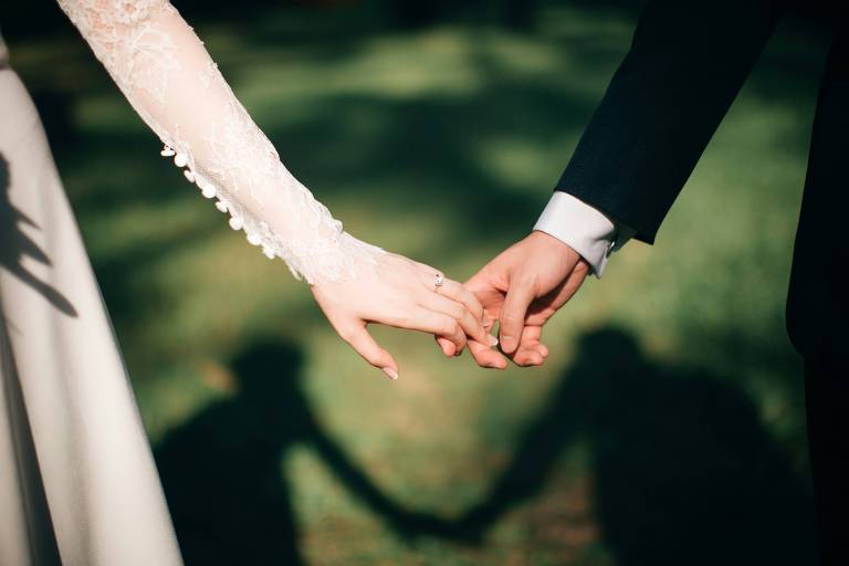 Noiva e noivo dão as mãos