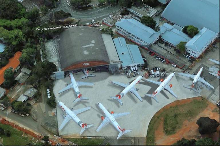 Imagem aérea de hangar com seis aviões ao redor