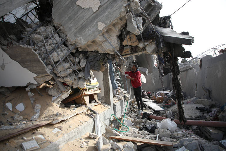 Homem em meio a edifício destruído após ataque aéreo em Rafah, no sul da Faixa de Gaza