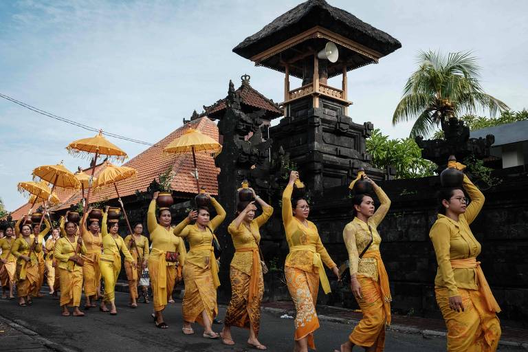 Mulheres hindus retornam da praia durante um ritual um dia depois de Nyepi, o dia de silêncio que marca o Ano Novo no calendário hindu balinês, em Jimbaran, Bali, em 12 de março de 2024