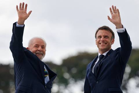 France's President Emmanuel Macron (R) and Brazil's President Luiz Inacio Lula da Silva (L) greet people after a bilateral meeting at the Planalto Palace in Brasilia, on March 28, 2024. (Photo by Ludovic MARIN / POOL / AFP)
