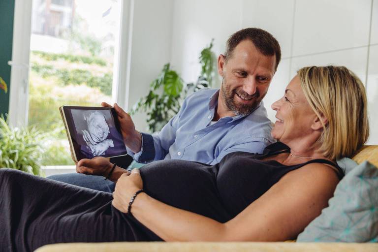 Um casal mais velho observa o resultado de uma ultrassonografia
