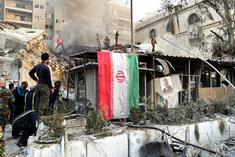 Bandeira iraniana nas ruínas do consulado do Irã na Síria, bombardeado por Israel, segundo a TV estatal iraniana