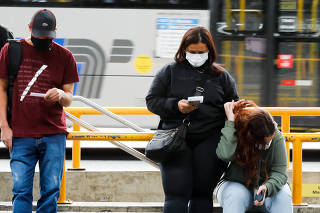 Passageiros com máscaras no terminal de ônibus da estação Santana do metrô