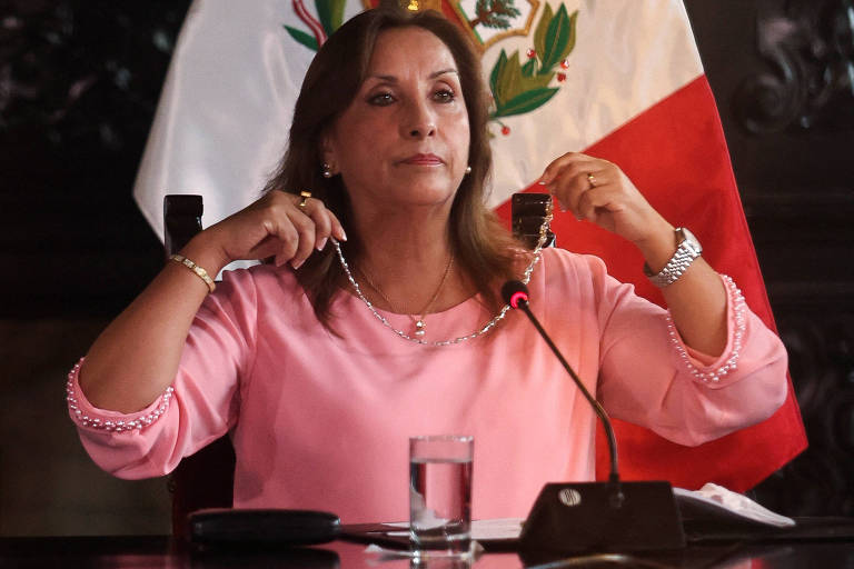 A presidente do Peru, Dina Boluarte, mostra joia a jornalistas em meio a investigação de enriquecimento ilícito.