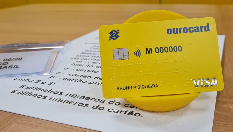 Cartão da visa amarelo com inscritos em braile