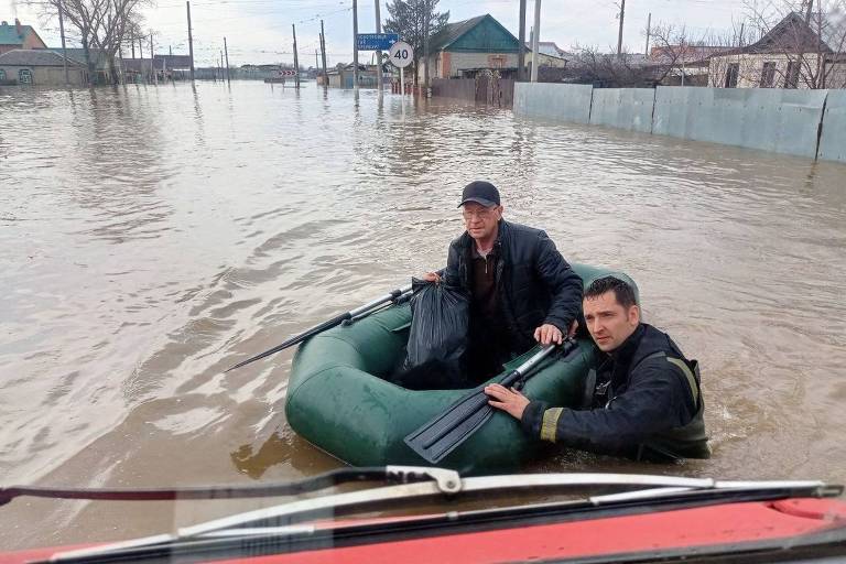 Equipes de resgate atravessam rua inundada para retirar moradores durante enchente em Orsk, região de Oremburgo, ao sul dos Montes Urais
