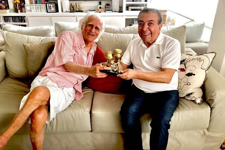 Ziraldo e Mauricio de Sousa segurando o troféu HQMIX, o Oscar dos quadrinhos, que homenageou ambos com as imagens do Menino Maluquinho e da Mônica