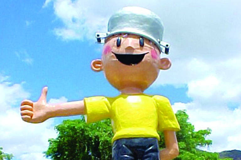estátua do Menuno Maluquinho, com blusa amarela, shorts pretos e panela na cabeça