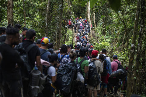 FILE ? A group of migrants cross a river in the Darien Gap, the narrow stretch of jungle terrain connecting Colombia and Panama, near Acandi, Colombia, Aug. 3, 2023. Until 2021, only a few thousand people crossed the gap each year. Now it?s a major and dangerous route north.  ORG XMIT: XNYT0473