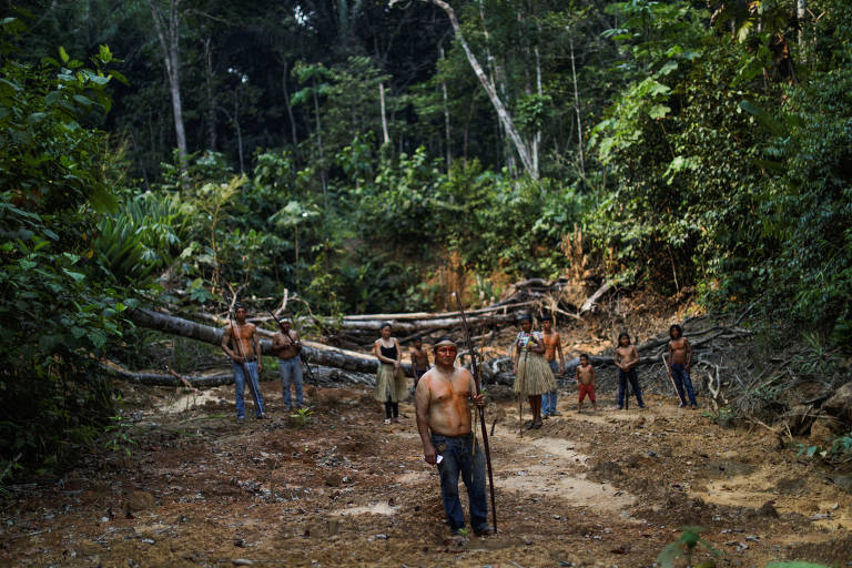 Indígenas posam para foto em clareira na floresta