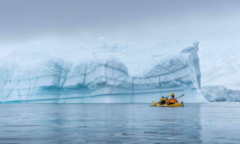 Barcos passam próximos aos icebergs da Antártida