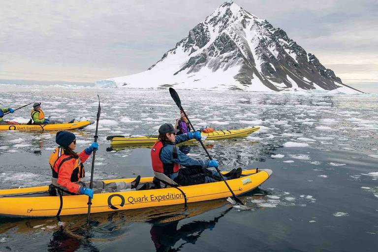 pessoas passeiam de canoa no mar antártico 