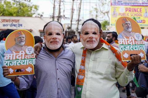 Supporters wear face masks of India's Prime Minister Narendra Modi at his roadshow in Dausa on April 12, 2024, ahead of the country's general elections. (Photo by Himanshu SHARMA / AFP)