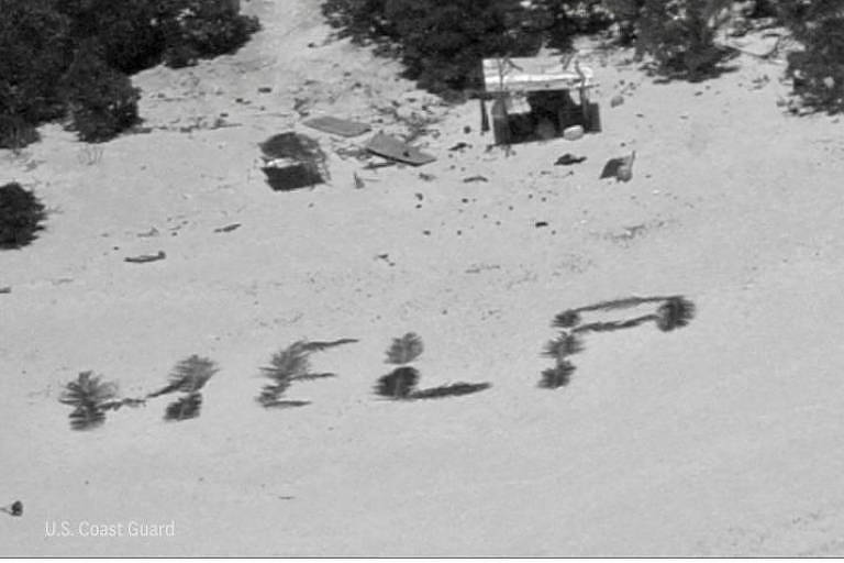Palavra HELP escrita na areia com folhas de palmeira, vista de cima