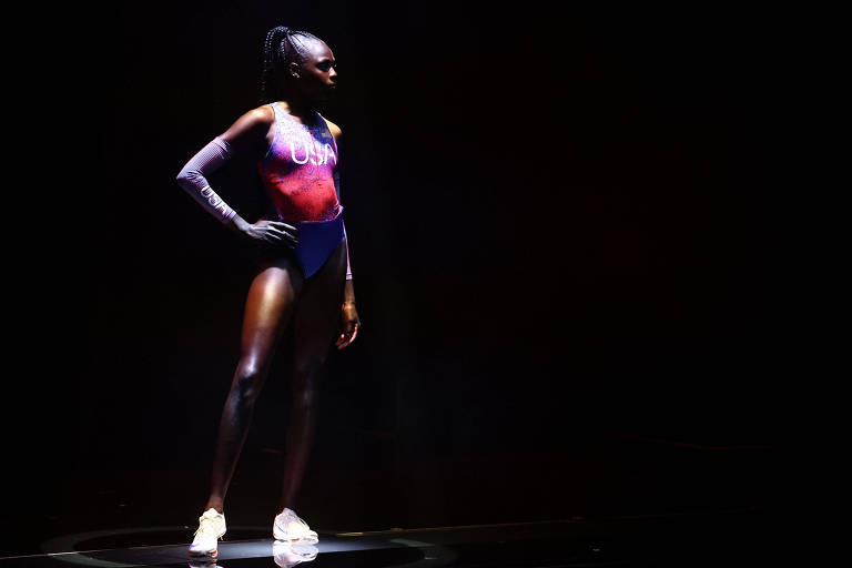 Mulher posa com uniforme da Nike para equipe feminina de atletismo dos EUA, com fundo preto