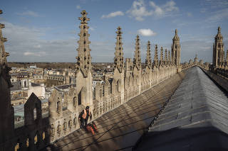 Toby Lucas, whose firm installed solar panels, on the roof King's College Chapel in Cambridge, England, March 14, 2024. (Hannah Reyes Morales/The New York Times)