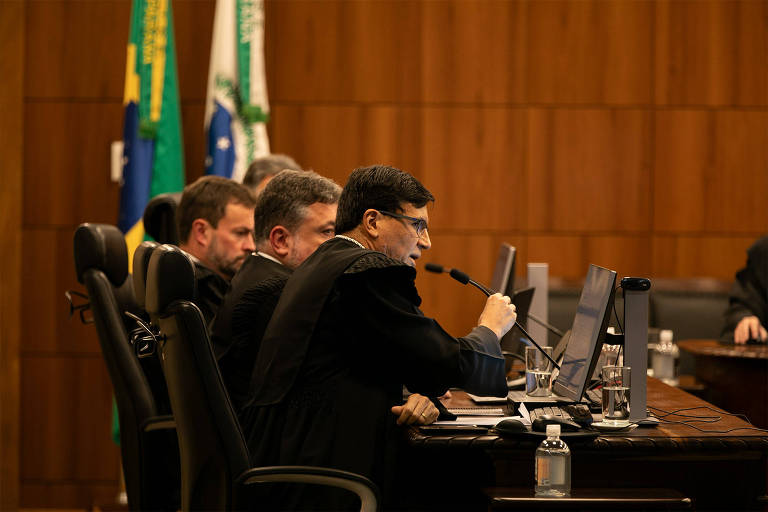 Foto mostra bancada com parte dos juízes sentados, um deles fala ao microfone