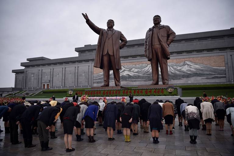 Pessoas se curvam frente a estátuas de ditadores norte-coreanos