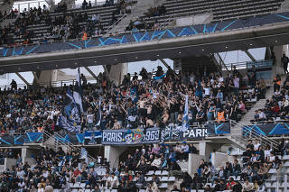 Soccer fans at Stade Charléty stadium for a Paris FC home game against Grenoble in Paris, April 6, 2024. (Dmitry Kostyukov/The New York Times)