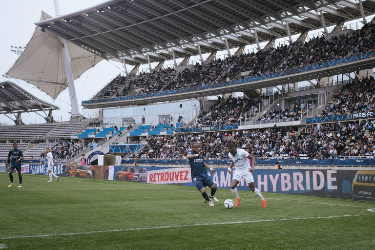 Jogadores do Paris FC e do Grenoble disputam a bola em partida pela segunda divisão do Campeonato Francês no estádio Stade Charléty, em Paris