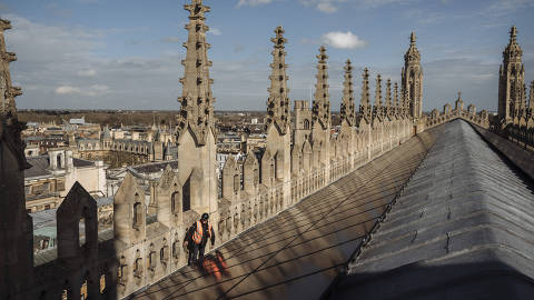 Toby Lucas, whose firm installed solar panels, on the roof King's College Chapel in Cambridge, England, March 14, 2024. KingÕs College Chapel is one of several British landmarks that have installed solar panels, gratifying climate campaigners and ruffling feathers among some traditionalists. (Hannah Reyes Morales/The New York Times) ORG XMIT: XNYT0633 DIREITOS RESERVADOS. NÃO PUBLICAR SEM AUTORIZAÇÃO DO DETENTOR DOS DIREITOS AUTORAIS E DE IMAGEM