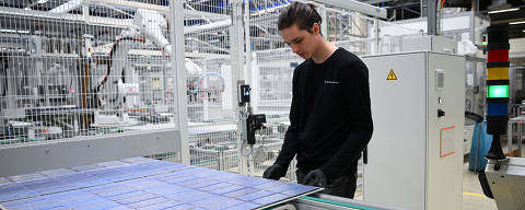 Max Lange, 19, a plant mechatronics engineering trainee from Oederan, stands next to a solar panel rolling off the assembly line as part of the last production of solar modules at the Meyer Burger Technology AG plant, due to an announced closure of the plant, in Freiberg, Germany March 12, 2024. REUTERS/Annegret Hilse ORG XMIT: HFS_AHI106