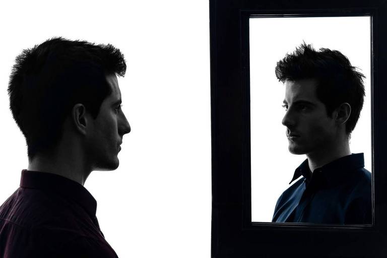 Homem se observando no espelho
