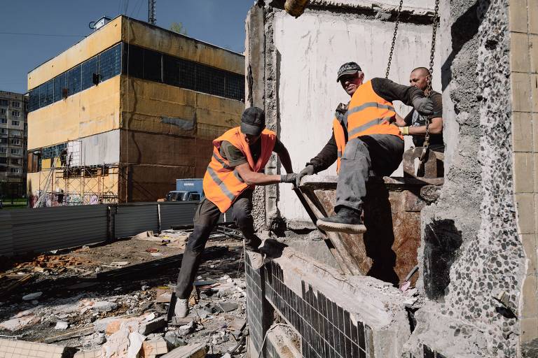 Trabalhadores da construção civil removem escombros de edifício bombardeado pelo Exército russo em Odessa