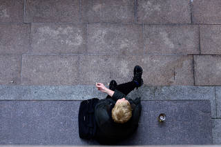 FILE PHOTO: A person smokes a cigarette in Canary Wharf in London