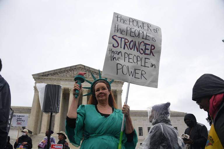 Manifestantes protestam em frente à Suprema Corte dos EUA, em Washington, em defesa da democracia 
