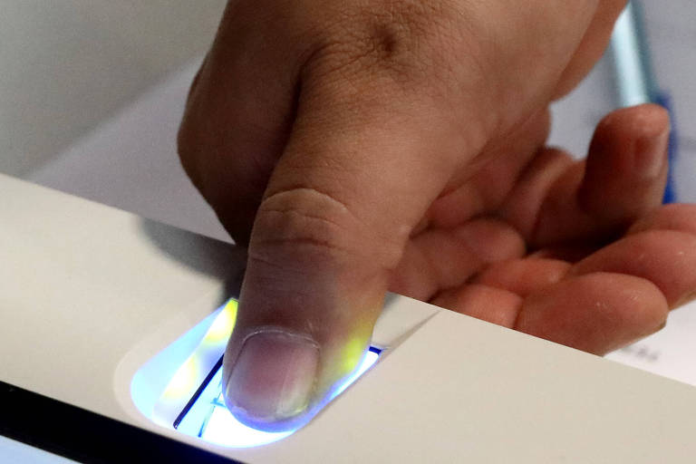 Pessoa coloca o dedo polegar na coleta da biometria da urna eletrônica