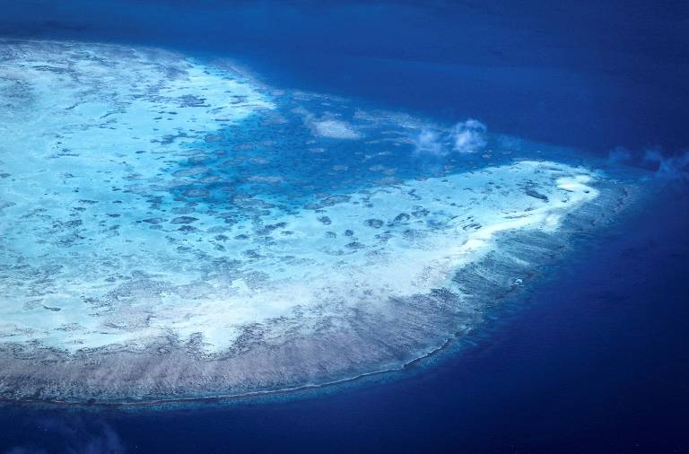 Vista aérea de recife gigante de cor branca em mar azul escuro