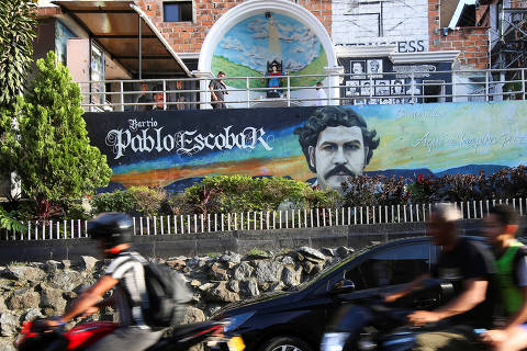 People ride past a mural dedicated to late Colombian drug lord Pablo Escobar, in Medellin, Colombia April 12, 2024. REUTERS/Juan David Duque ORG XMIT: GGGCDG13