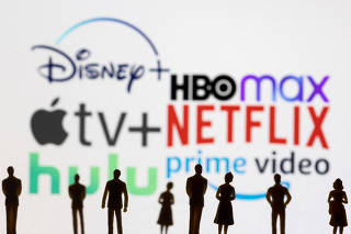 FILE PHOTO: Toy figures of people are seen in front of the displayed Disney +, HBO Max, Apple TV, Netflix, Hulu and Prime logos, in this illustration