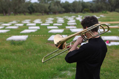 A man plays trumpet during an inauguration ceremony following the renovation of a burial ground for refugees and migrants in the village of Kato Tritos, on the island of Lesbos, Greece, April 17, 2024. REUTERS/Elias Marcou ORG XMIT: HFS-LGO110
