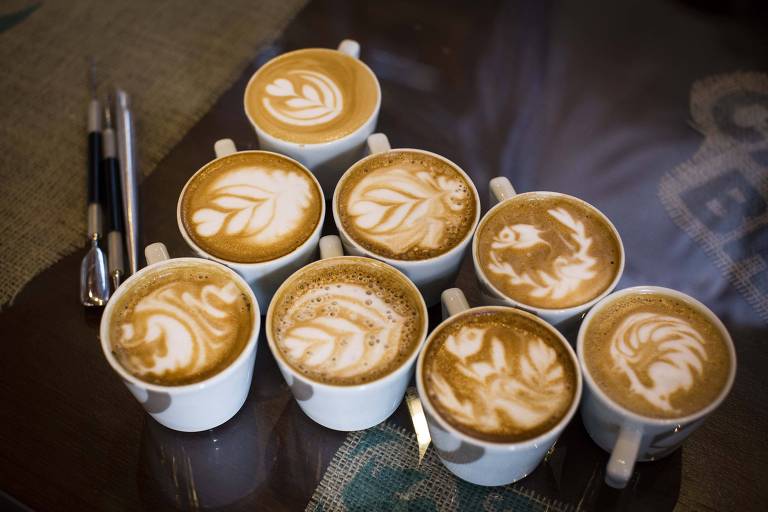 Várias xícaras de café com leite vaporizado formando desenhos diversos