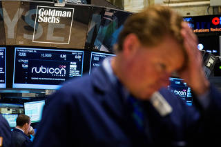FILE PHOTO: Goldman Sachs logo above a trader on the floor of the New York Stock Exchange shortly after the opening bell in the Manhattan borough of New York