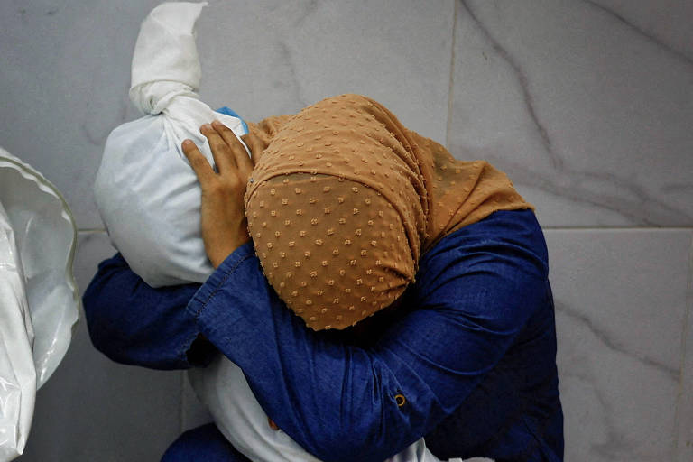 Imagem de palestina abraçada a menina morta ganha prêmio de foto do ano