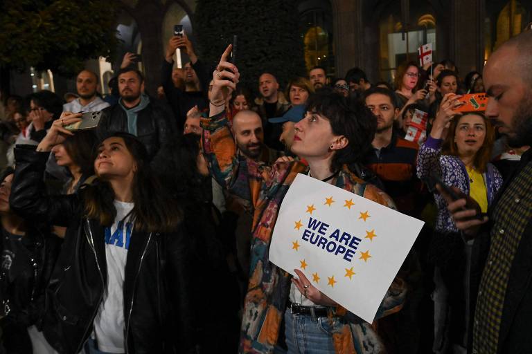 Grupo ativista pró-democracia na Geórgia tira fotos com celulares durante protesto